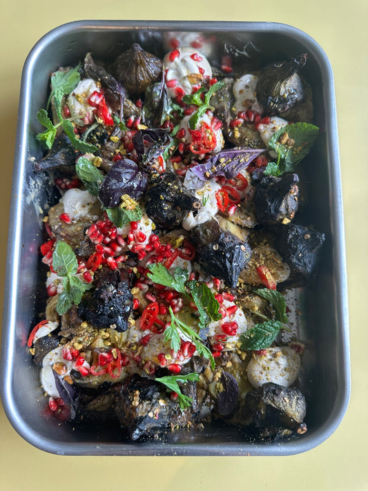 Berenjena asada, tahini, granada, almendras y hojas